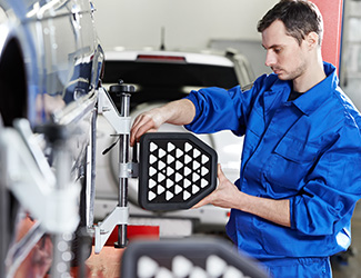 tech aligning tires on car