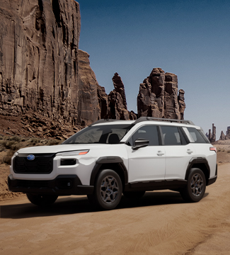 2026 Suabru Outback parked on a dirt road with mountains behind it