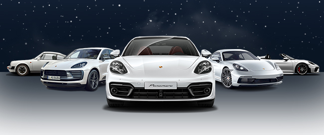 Photo of Five snow white and silver Porsche models in a snow scene, evoking the holiday season