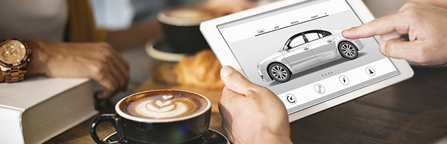 young man in pajamas car shopping on a laptop