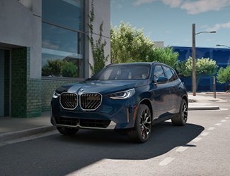 Gray BMW SUV driving though water on a beach