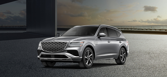 A gray Genesis G80 parked with water in the background