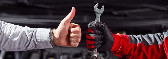 2 service techs arms giving thumbs up