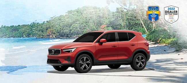 New premiere Volvo on an idyllic red sand beach with water and palm trees